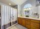 This bathroom offers modern lighting, vanity with ample storage, and a shower-tub combination with curtain at 26338 Glen Eagle, Leesburg, FL 34748