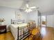 Sunlit bedroom with laminate wood flooring, ceiling fan, and an open doorway to an adjacent bathroom at 26338 Glen Eagle, Leesburg, FL 34748