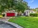 Charming single-story home boasts a red garage door and well-maintained landscaping at 26338 Glen Eagle, Leesburg, FL 34748
