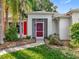 Inviting front entrance with a red door and lovely landscaping at 26338 Glen Eagle, Leesburg, FL 34748