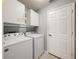 Functional laundry room with a full-size washer and dryer and convenient above-appliance storage cabinets at 26338 Glen Eagle, Leesburg, FL 34748