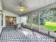 Comfortable screened patio with patterned floors and outdoor furniture, offering a great view of the landscaped yard at 26338 Glen Eagle, Leesburg, FL 34748