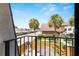 Relaxing balcony view with seating, umbrella and views of palms and complex parking at 2920 Poplar Ave, Leesburg, FL 34748