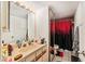 Bright bathroom with a large mirror, vanity, and a shower with red and black curtain at 2920 Poplar Ave, Leesburg, FL 34748