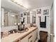 Bathroom featuring a sink, mirror, shower, and vanity with wall decorations at 2920 Poplar Ave, Leesburg, FL 34748