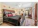 Bedroom with a large bed, ceiling fan, mirrored closet, and an ensuite bathroom entrance at 2920 Poplar Ave, Leesburg, FL 34748