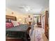 Bedroom with a large bed, ceiling fan, mirrored closet, and an ensuite bathroom entrance at 2920 Poplar Ave, Leesburg, FL 34748