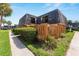 Charming two-story townhouse with wood siding, partial view of palm trees and green landscaping at 2920 Poplar Ave, Leesburg, FL 34748