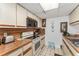 Galley kitchen with white cabinets, wood countertops, and appliances; including stove, oven, and microwave at 2920 Poplar Ave, Leesburg, FL 34748