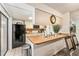 Efficient kitchen featuring a breakfast bar, black appliances, and plenty of counter space at 2920 Poplar Ave, Leesburg, FL 34748