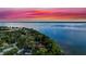 Aerial view of property and lake with a beautiful pink and blue sunset sky at 30523 Orange Dr, Leesburg, FL 34748
