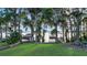 Lush green backyard with mature trees and a dock leading to the tranquil lake at 30523 Orange Dr, Leesburg, FL 34748