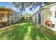 View of the green backyard space between house and detached unit with grass at 30523 Orange Dr, Leesburg, FL 34748
