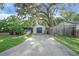 View of the detached garage with double doors and a long concrete driveway at 30523 Orange Dr, Leesburg, FL 34748