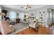 Cozy living room featuring hardwood floors, area rug, ceiling fan and natural light at 30523 Orange Dr, Leesburg, FL 34748