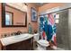 This renovated bathroom features a classic vanity, a decorative mirror and colorful shower curtain at 3184 Maltby Dr, Deltona, FL 32738