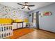Charming bedroom features an orange rug, a dinosaur theme, and plenty of space to play at 3184 Maltby Dr, Deltona, FL 32738