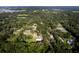 An aerial view showcases a quiet neighborhood with homes nestled among lush greenery and mature trees at 3359 County Road 513, Wildwood, FL 34785