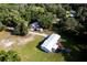 An aerial view displays the expansive lot with a manufactured home, outbuildings, and trampoline with ample green space at 3359 County Road 513, Wildwood, FL 34785