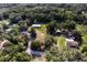 An aerial view captures a home with a separate garage, surrounded by verdant greenery and a tranquil atmosphere at 3359 County Road 513, Wildwood, FL 34785