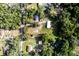 Aerial view highlighting property lines, showcasing home, detached garage, and surrounding wooded acreage at 3359 County Road 513, Wildwood, FL 34785