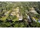 Aerial view of a home with detached garage surrounded by lush greenery and trees, on spacious land at 3359 County Road 513, Wildwood, FL 34785