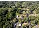 An aerial view displays a quaint home nestled in a lush, green landscape filled with mature trees at 3359 County Road 513, Wildwood, FL 34785