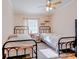 Bedroom with two beds, ceiling fan, window, and decorative shelving at 3359 County Road 513, Wildwood, FL 34785