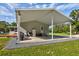 Exterior view featuring a covered carport, grill, and extra refrigerator at 3359 County Road 513, Wildwood, FL 34785