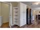Bright kitchen features stainless steel refrigerator, white cabinets, shelving, and wood-look floors at 3359 County Road 513, Wildwood, FL 34785