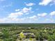 Aerial view of a home nestled in a lush, green landscape surrounded by trees at 37007 Forestdel Dr, Eustis, FL 32736