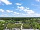 Aerial view showing a property with outlined borders, situated in a verdant, wooded area under a partly cloudy sky at 37007 Forestdel Dr, Eustis, FL 32736