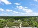 Aerial view of a home surrounded by lush trees with a mix of blue skies and clouds above at 37007 Forestdel Dr, Eustis, FL 32736