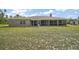 Backyard view of a home featuring a screened-in patio and lush lawn at 37007 Forestdel Dr, Eustis, FL 32736