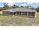 Backyard view of a home featuring a covered patio and lush lawn at 37007 Forestdel Dr, Eustis, FL 32736