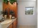 Bright bathroom features a wood vanity with neutral countertop, ceramic tile floor, and natural light from the window at 37007 Forestdel Dr, Eustis, FL 32736