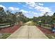 Long driveway with mature trees and ADT security system at 37007 Forestdel Dr, Eustis, FL 32736