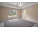Spacious main bedroom features tray ceilings, large windows, and neutral tones at 37007 Forestdel Dr, Eustis, FL 32736
