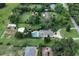 Expansive aerial view showcasing the home, pool, outbuildings, and surrounding greenery at 37138 Lake Yale Pl, Grand Island, FL 32735