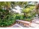 Secluded backyard with bench seating and lush tropical foliage at 37138 Lake Yale Pl, Grand Island, FL 32735