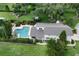 Aerial view of the backyard with a large in-ground pool, green space, and mature trees at 37138 Lake Yale Pl, Grand Island, FL 32735