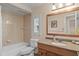 Clean bathroom design featuring neutral tile, wood vanity, and large mirror at 37138 Lake Yale Pl, Grand Island, FL 32735