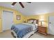 Comfortable bedroom with a ceiling fan, lamps, and a beautiful wooden headboard at 37138 Lake Yale Pl, Grand Island, FL 32735
