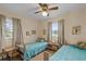 Bright bedroom with twin beds, each with a blue comforter, and views from the two windows at 37138 Lake Yale Pl, Grand Island, FL 32735