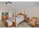 Spacious primary bedroom showcasing a wooden four-poster bed and ample natural light at 37138 Lake Yale Pl, Grand Island, FL 32735