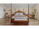A cozy primary bedroom featuring a wooden four-poster bed and ample natural light at 37138 Lake Yale Pl, Grand Island, FL 32735