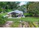 Metal outbuilding houses a UTV, tools, and equipment, complemented by a lush lawn and cultivated garden at 37138 Lake Yale Pl, Grand Island, FL 32735
