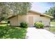 View of outbuilding with secure door, concrete sidewalk, and manicured landscaping at 37138 Lake Yale Pl, Grand Island, FL 32735