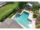 Aerial view of pool with surrounding lush landscaping and sunbathing area at 37138 Lake Yale Pl, Grand Island, FL 32735