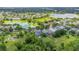 A beautiful aerial view of the community and home with mature landscaping adjacent to a park and pond at 4445 Blue Major Dr, Windermere, FL 34786